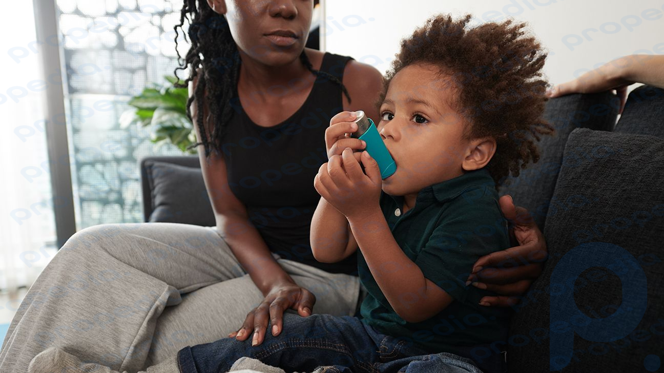 criança sentada ao lado da mãe usando um inalador para asma-1