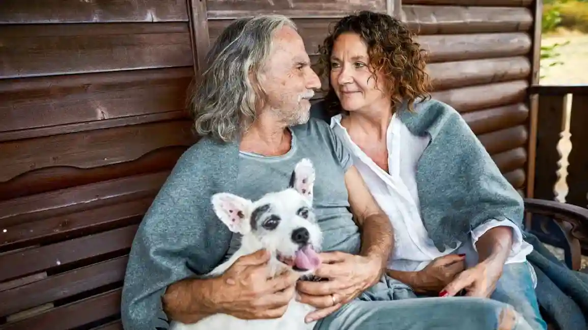 older man and woman sitting with dog