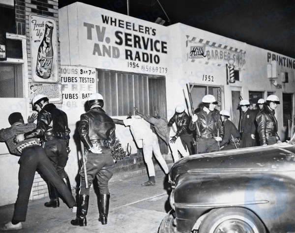 1966-Los Ángeles, CA- Los agentes de policía registran a los jóvenes negros de Watts a finales del 15 de marzo tras un breve estallido racial.  El segundo en la zona devastada por los conflictos en ocho meses.