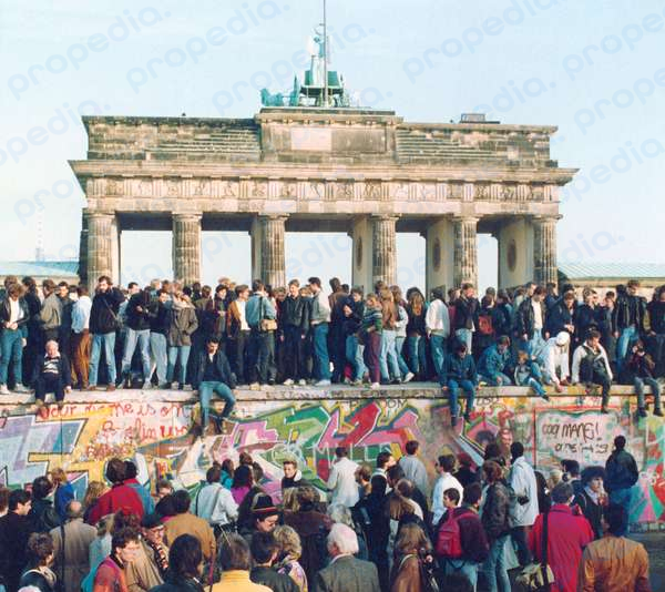 Немцы с Востока и Запада стоят на Берлинской стене перед Бранденбургскими воротами, фотография 10 ноября 1989 года, через день после открытия стены.