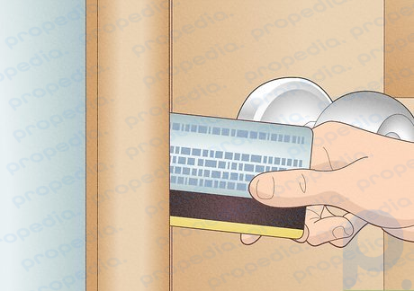 Paso 2 Inserte la tarjeta entre la puerta y el marco de una cerradura con perno de resorte.