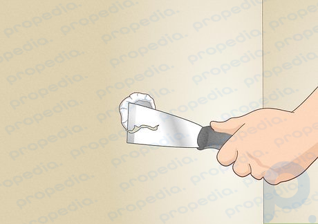 Étape 1 Utilisez un couteau à mastic rigide pour gratter la surface autour du trou, en retirant le matériau texturant.