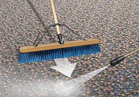 Pase una escoba grande sobre la superficie mientras los limpia con una manguera.