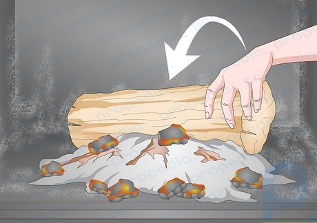 Paso 3 Coloque el tronco grande en la parte trasera de la estufa, detrás de las brasas.