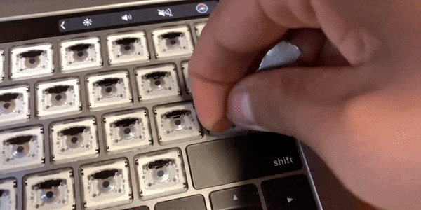 MacBook キーボードの掃除方法: ツールをキーの中央に上から挿入します。