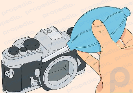 Paso 3 Utilice el soplador para eliminar las partículas del exterior del cuerpo de la cámara.