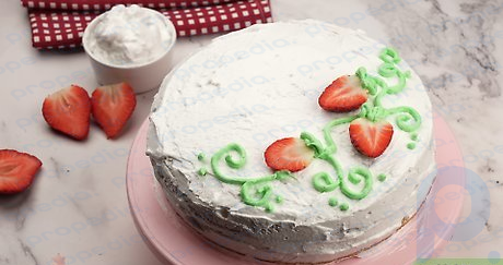 Step 1 Pipe vines onto a frosted cake, then add sliced strawberries to them.