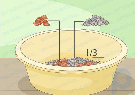 Step 2 Fill the bottom of the pot with bottles, small rocks, or broken pottery.